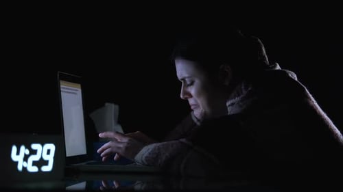 Woman Typing on Laptop at Night in Dark Room