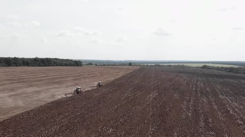 Tractors Plowing Field in Rural Landscape Aerial View