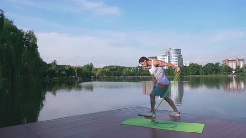 Man Exercising with Resistance Bands on Dock
