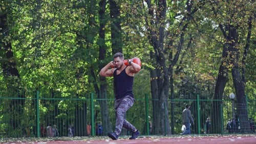 Man training at stadium. Fit athlete doing exercises at stadium