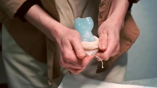 A woman occupied with hand made candles production