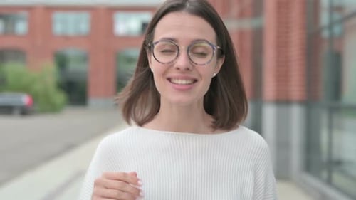 Young Woman Waving and Talking to the Camera