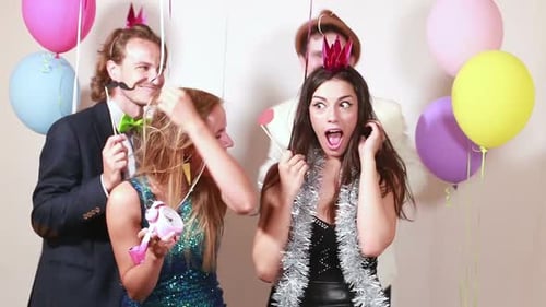Beautiful friends having fun in party photo booth