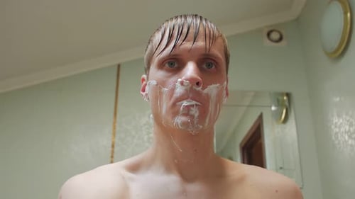 Homem se barbeando no banheiro