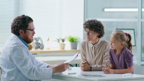 Doctor Consults with Child and Adult in Office