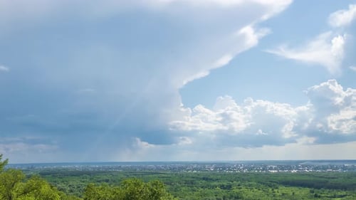 Timelapse. De grands cumulus flottent dans le ciel. Une petite ville à l'horizon