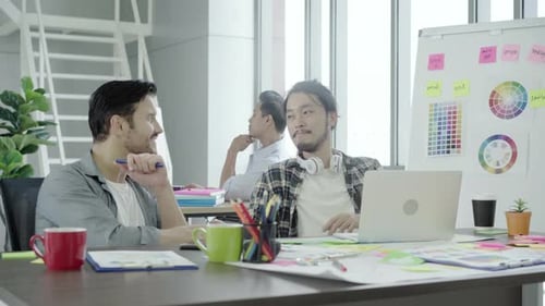 Office Workers Collaborating on Laptop at Modern Workplace
