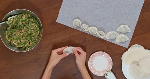 Hands Making Dumplings with Filling, Overhead View