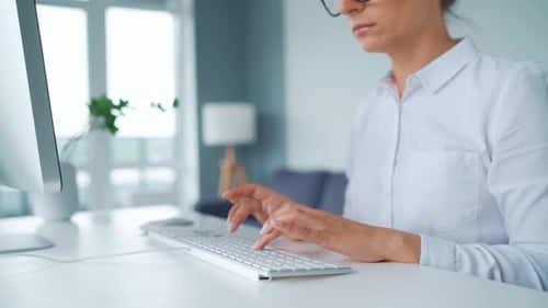 Woman Typing on Computer Keyboard at Modern Office