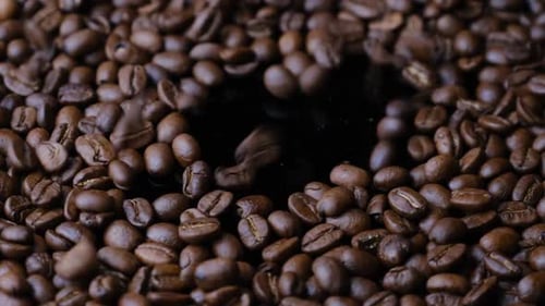 Kaffeebohnen fallen auf den Teller und drehen sich langsam