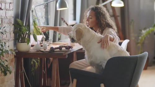 Woman pets her dog in her home