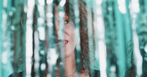 Intriguing curly girl dancing through a glitter curtain