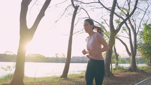 Asian young beautiful sport woman running on street in public park.