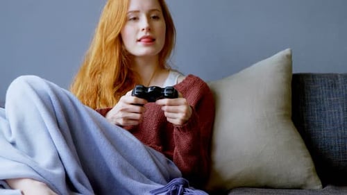 Woman Playing Video Game on Couch Relaxing