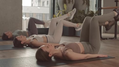 Women Doing Abs Exercises during Training in Studio
