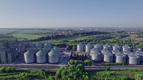 Commercial Grain Or Seed Silos In Sunny Spring Rural Landscape