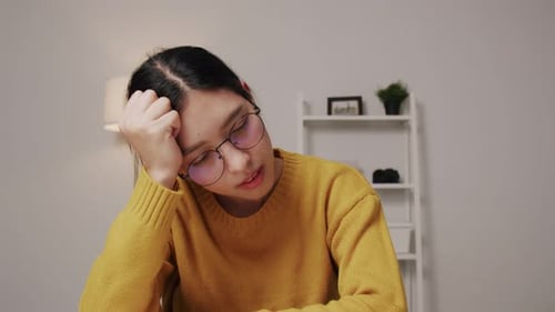 Young Adult Woman with Headache Rubbing Head Indoors