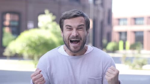Handsome Man Celebrating Success Gesture in Office