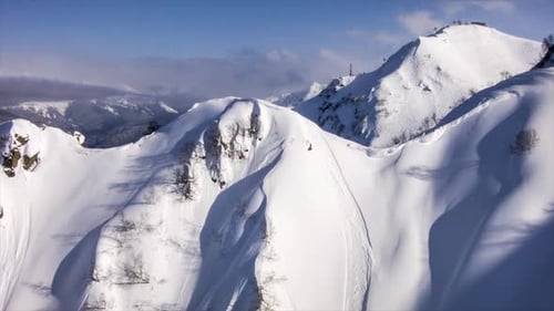 Un hélicoptère atterrit pour embarquer des skieurs en montagne.