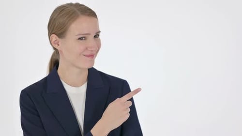 Woman Points and Smiles on White Background