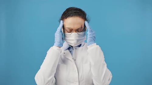 Woman with a Headache wearing Medical Protective Gear