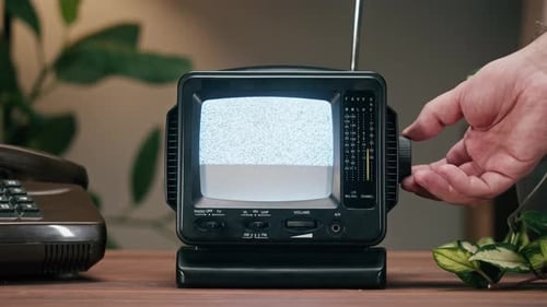 Hand Adjusts Channel on Retro Television