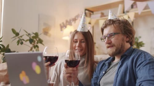 Couple Celebrating Birthday Over a Video Call with Wine