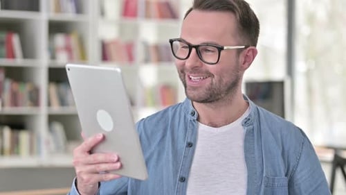 Smiling Man Having Video Call With Tablet Indoors