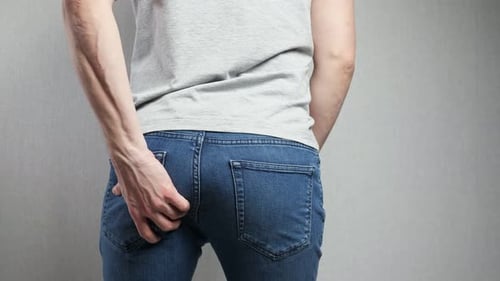 Person Reaches for Black Leather Belt