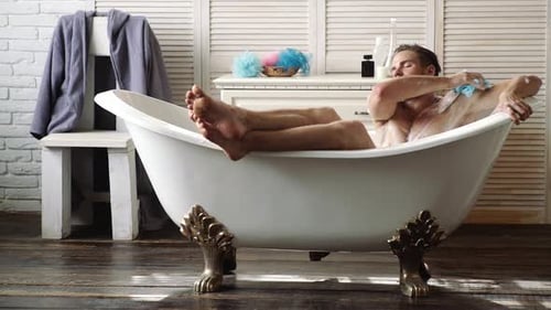 Man Relaxing in Spa Bath. Bodycare, Wellness. Man with Muscular Body in Bath. Bath Bathing Shower