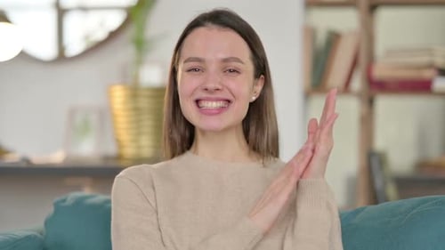 Smiling Woman Clapping in an Indoor Setting