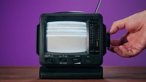 Hand Adjusts Channel on Retro Television