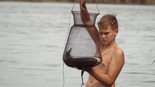 L'adolescent examine le poisson pêché