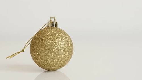 Golden Christmas ornament on white background close-up 4K 2160p 30fps UltraHD tilting footage - Shi
