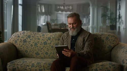 Mature Man Using Tablet on Couch