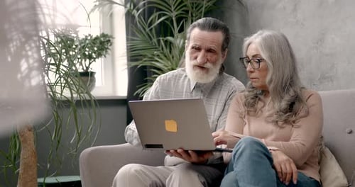 Senior Couple Using Laptop Computer Together at Home