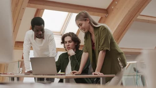 Young Professionals Collaborating on Laptop in Modern Office