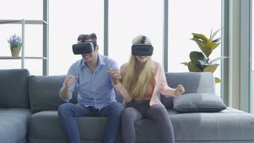 Couple Experiencing Virtual Reality Headsets Together at Home