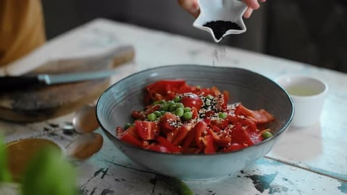 Hands Adding Spice To Salad