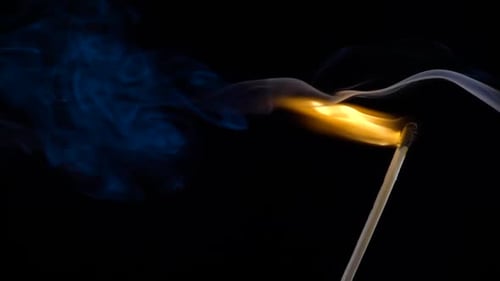 Burning Match Stick with Blue Smoke on Black