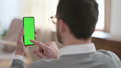 Rear View of Man Using Smartphone with Chroma Key Screen
