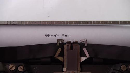 Typing phrase Thank You on retro typewriter. Close up.