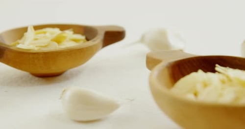 Minced Garlic in Wooden Bowls on White Surface