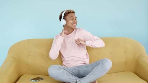 Young Adult Dancing to Music on Sofa