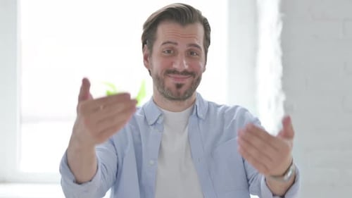 Man Smiling and Inviting Someone Closer