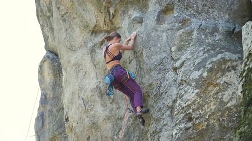 Strong Female Climber Climbing Steep Wall of Rocky Mountain