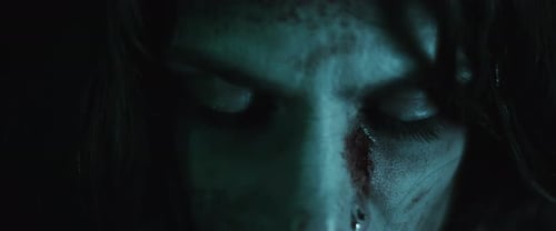 Injured Woman's Face with Bruises in the Dark