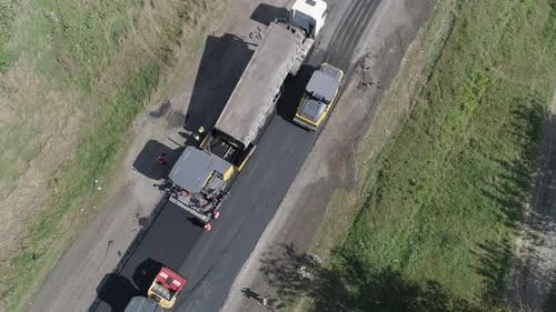 Luftaufnahme von LKWs auf einer im Bau befindlichen Straße