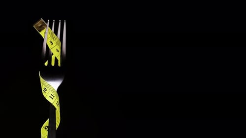 Measuring Tape Wrapped Around Fork on Black