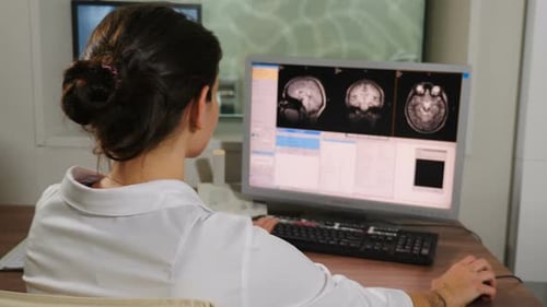 Arzt im Krankenhaus untersucht Computerbildschirm oder Monitor, während sich der Patient einer MRT-Untersuchung unterzieht
